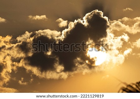 picture of sun behind dark clouds