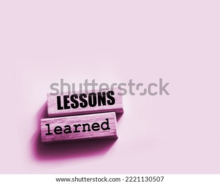 Lessons learned text on Wood blocks on pink. Business education concept. Royalty-Free Stock Photo #2221130507