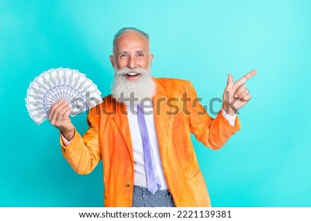 Photo of funky handsome grandfather arm hold usd banknotes direct finger empty space isolated on turquoise color background