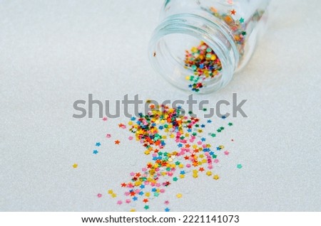 Stars confetti out of jar on white background