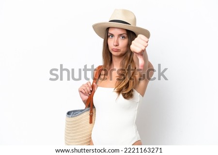 Young caucasian woman in swimsuit in summer holidays isolated on white background showing thumb down with negative expression