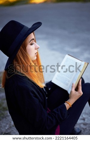 girl by the road with books and a suitcase