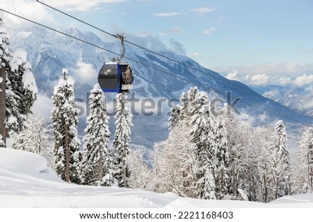 New modern spacious big cabin ski lift gondola against snowcapped forest tree and mountain peaks covered in snow landscape in luxury winter alpine resort. Winter leisure sports, recreation and travel Royalty-Free Stock Photo #2221168403