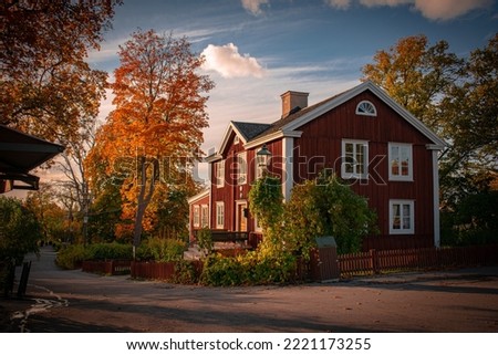 red houses in sweden with green landscape and sun light Royalty-Free Stock Photo #2221173255