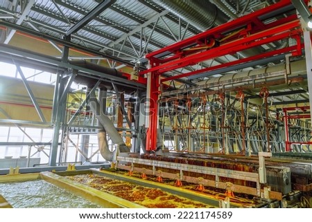 Production process of galvanic copper, nickel and chrome plating steel metal products. Lifting of metal products by overhead crane from bath of electrochemical plating. Fragment of a galvanic line.