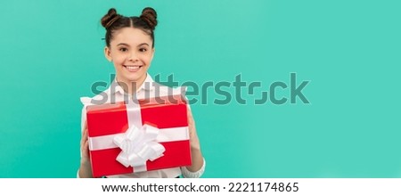 cheerful school kid with gift box on blue background, birthday. Kid girl with gift, horizontal poster. Banner header with copy space.