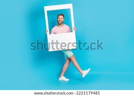 Full size photo of handsome young guy cheerful walking model window frame dressed stylish pink look isolated on aquamarine color background