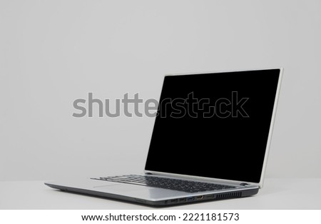 Blank gray  laptop screen on black wooden table. Cozy workplace at home. Mock up. Blank black laptop monitor on wooden table without decor elements for comfortable remote work. Mockup.