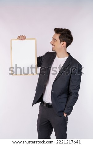 Portrait of happy businessman showing blank signboard on isolated white background. Empty copy space area for slogan or advertising text message. Success in business, job, and education concept.