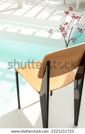 Simplicity chair in the backyard pool. Wooden material. Scandinavian design. Mid century. Minimalist style. Lifestyle. Furniture. 