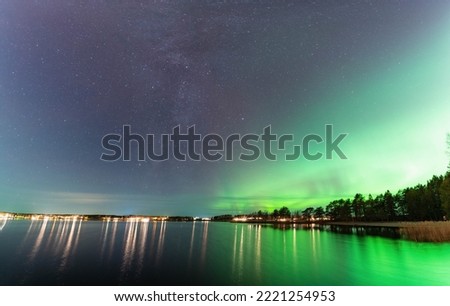 Beautiful Milky Way galaxy close to Aurora, scenic panorama of Northern Lights over calm night Stocksjo lake in Northern Sweden, Umea city, long exposure night photo, selective focus