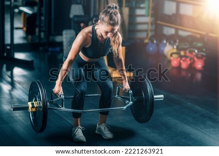 Woman doing trap bar deadlift in the gym. Royalty-Free Stock Photo #2221263921