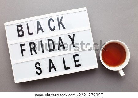 friday sale announcement on a writing box on grey background with cup of tea.