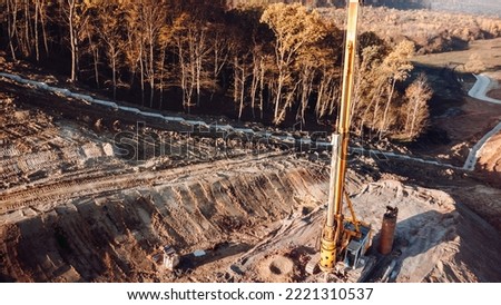 Aerial view of highway construction site. Rotary drills working and making holes in the ground on Highway construction site for viaduct and bridge Royalty-Free Stock Photo #2221310537