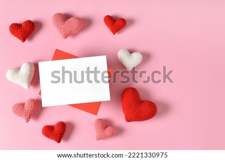 A mock-up of a kraft envelope with a blank sheet and knitted hearts.