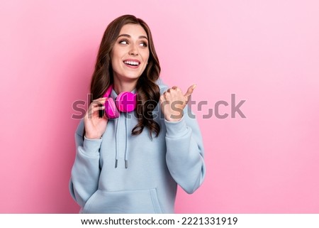 Photo of positive nice lady look indicate thumb finger empty space isolated on pink color background