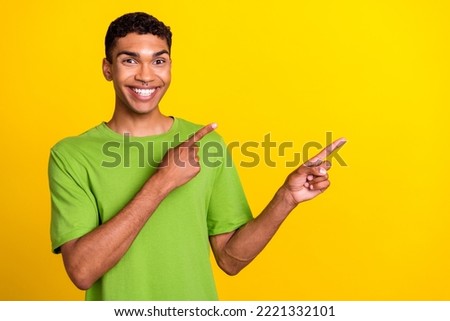 Photo of cheerful funny person indicate fingers empty space offer promo isolated on yellow color background