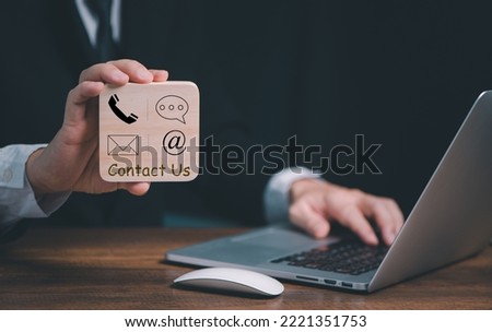 CONTACT US, Hand of Businessman holding wooden block with  mail,phone,email, chat icons. Business cutomer support and service concept, copy space.