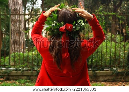 Degree of a wonderful engineer in a red suit with her laurel crown. Shooted in a italian green park with a little wind. Congratulation! Royalty-Free Stock Photo #2221365301