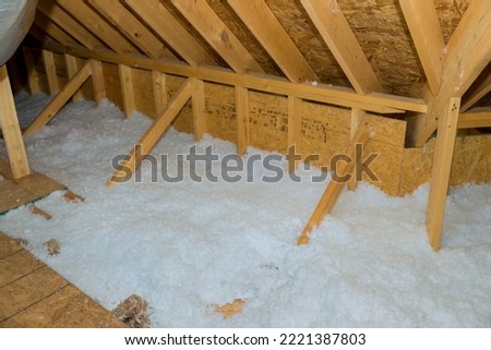 New homes attic insulation roof is being poured with eco wool insulation for purpose of insulating it Royalty-Free Stock Photo #2221387803
