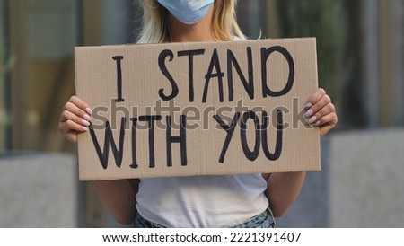 I STAND WITH YOU on cardboard poster in hands of female protester activist. Stop Racism concept, No Racism. Rallies against racism and police brutality. Peaceful life of blacks matters. Close up.