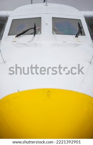 Close front outside view of a white jet plane cockpit.