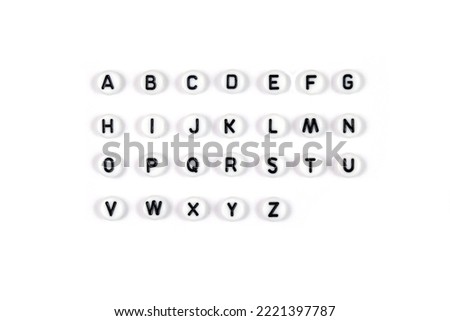 Top view of the English alphabet made of white beads with the English alphabet scattered on a white background with space for text. The concept of the development of thinking