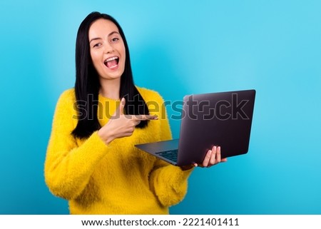 Photo of adorable gorgeous pretty girl with straight hairdo wear yellow  sweater directing at laptop on sale isolated on blue color background
