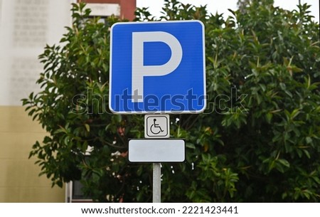Disabled parking lot traffic sign. Street symbol with a wheelchair. Extra place to park a car for people that are handicapped. This place is the most accessible area to park a car.