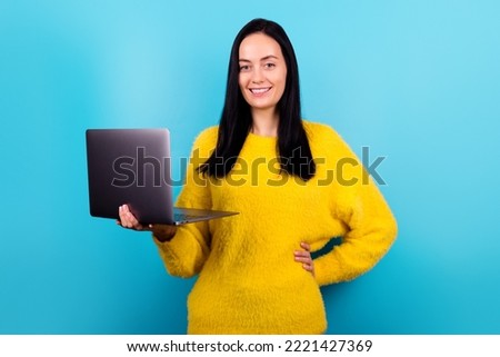 Photo portrait of business woman keeping laptop smiling in yellow fluffy sweater isolated blue color background
