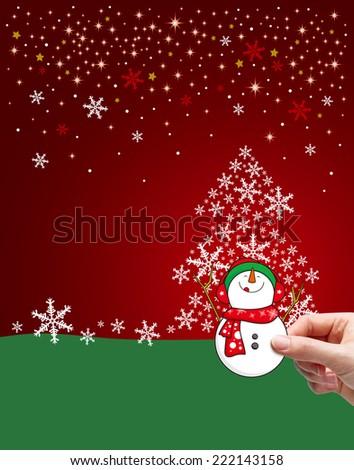 Young woman hand holding snowman in front of christmas tree
