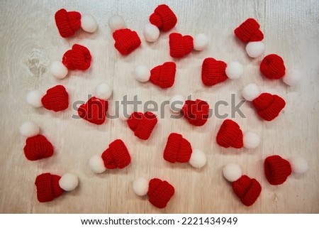 Small knitted hats as accessories for sewing production. Lots of bright red objects. Christmas and New Year decoration.