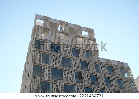 Exterior of modern white openwork house. Architectural detail of close-up on windows and texture wall. Real estate, residential apartment and office. Living apartments or office building architecture.