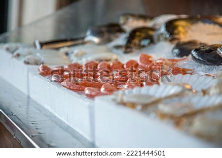 Pile of fresh red shrimps for sale on the seafood market, seafood on ice in Greece. Royalty-Free Stock Photo #2221444501