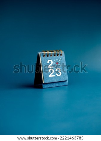 Happy new year 2023 background. 2023 numbers year with target icon on blue small desk calendar cover standing on blue background, vertical style. Business goals and success concepts. Royalty-Free Stock Photo #2221463785