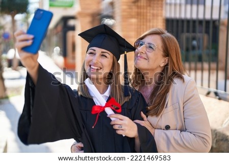 Mother and daughter making selfie by the smartphone celebrating graduation at university