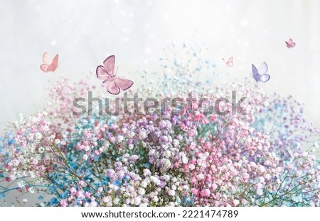 Beautiful gentle spring light background image in pink pastel colors with fluffy small flowers and a group of butterflies fluttering over flowers. Royalty-Free Stock Photo #2221474789
