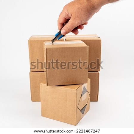 Cardboard box on a white background. Open the cardboard boxes with a utility knife. close-up.
