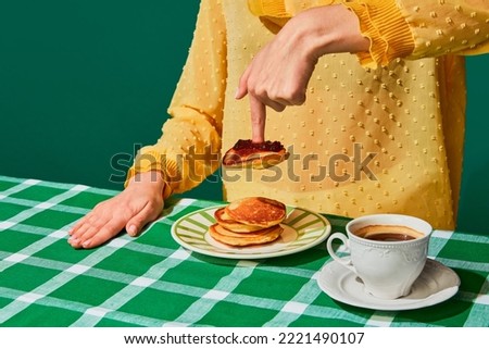 Woman having delicious breakfast with sweet pancakes and jam on green tablecloth. Vintage, retro style interior. Food pop art photography. Complementary colors. Copy space for ad, text