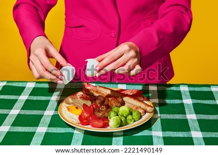 Woman cooking fried eggs, English breakfast on plate on green tablecloth. Healthy food. Vintage, retro style interior. Food pop art photography. Complementary colors. Copy space for ad, text