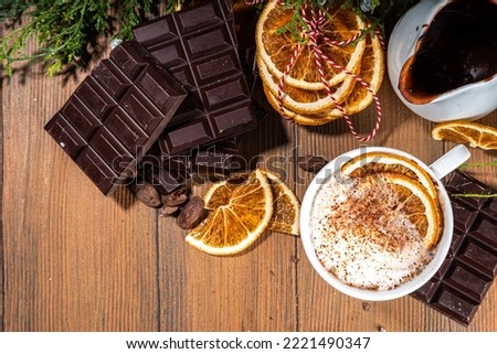 Orange hot cocoa drink. Homemade winter Christmas dark spicy hot chocolate with dried orange, with chocolate and orange slices on wooden cozy background 