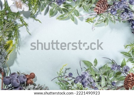 Christmas and New Year winter flowers greeting card background. Tender cute pastel White Christmas flatlay with xmas tree twig, snowy winter berry, pink white flowers, pine cone top view copy space