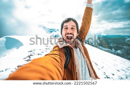 Handsome man taking selfie on winter snow mountain - Young hiker walking outside in white forest - Sport, technology and winter people concept