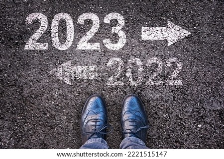 Direction 2023 written on asphalt road background with legs, new year business concept