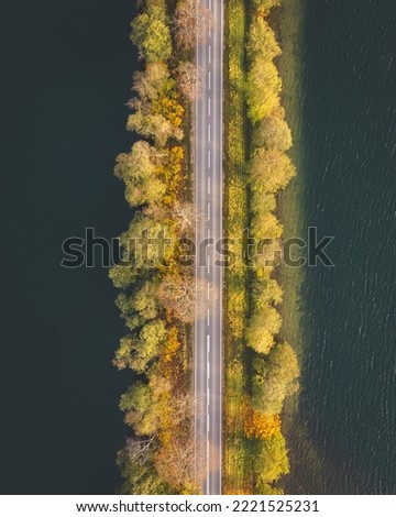 The picture presents road from above surrounded by trees. Road is dividing two lakes and is located in northern Poland - Kashubian  Landscape Park. The spot is called Brama Kaszubska - Kashubian Gate.