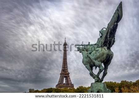 The France Reborn (La France Renaissante) Statue on the Bir Hakeim Bridge in Paris, France, with Eiffel Tower in the background on a cloudy afternoon