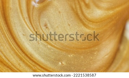 Glitter paint flow. Molten gold texture. Floating ink. Defocused yellow orange sparkling fluid motion. Abstract art background. Royalty-Free Stock Photo #2221538587