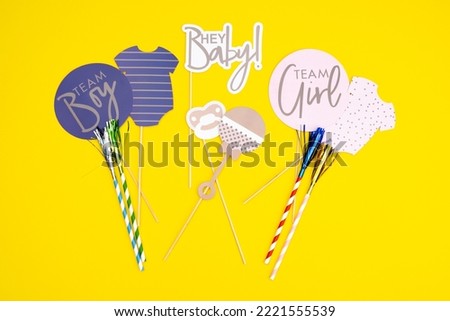 Background of the day of gender reveal party. Invitation card, party supplies, birthday whistles, party glasses and hats, gift boxes, flags and napkins.