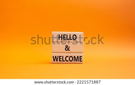 Hello and Welcome symbol. Concept words Hello and Welcome on wooden blocks. Beautiful orange background. Business and Hello and Welcome concept. Copy space.
