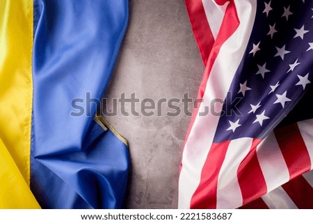 United States of America and Ukrainian flags together on one picture. Ukraine and US Partnership during war of 2022 concept background.